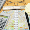 land surveyor mapping tools, pen, calculator, and ruler with a white map on a desk